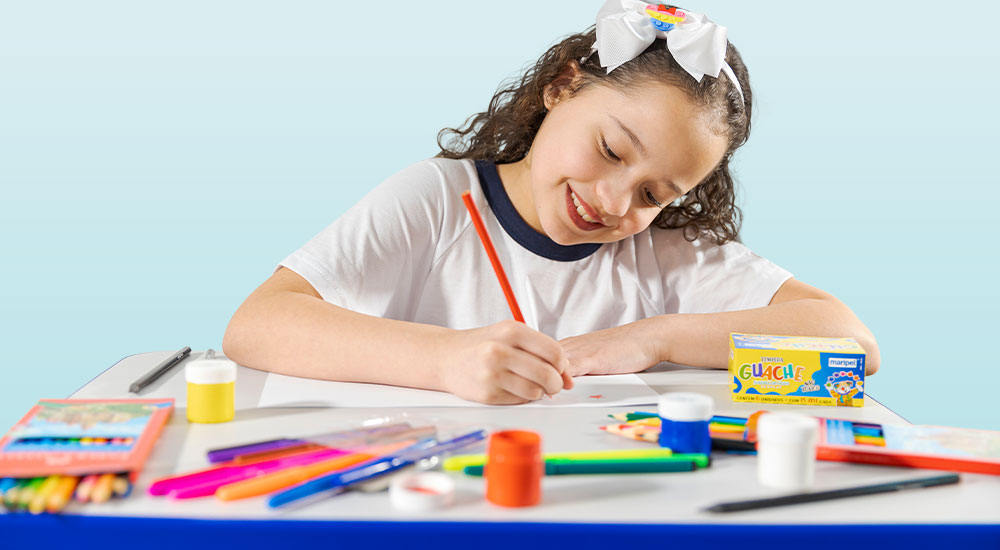 Menina vestida com uniforme escolar fazendo desenhos.